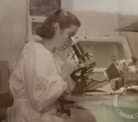 Pnina Weissberger (Kuba’s wife) at a lab microscope.